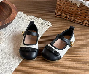 Detail of children's tweed Mary Jane shoes with black bow and gold button