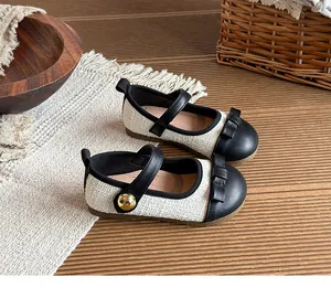 Detailed view of girl's black and white Mary Jane princess shoes with tweed and bow