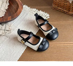 Close-up detail of stylish girls' tweed Mary Jane shoes with black leather bow accent