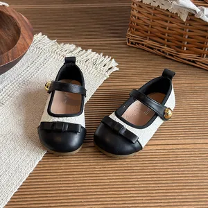 Classic black and white girls' Mary Jane shoes with bow detail and gold button