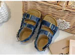 Dettaglio delle scarpe in denim blu da bambina con frange e fibbie dorate di tendenza