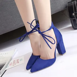 Detalle de sandalias de gamuza azul con punta fina, tacón grueso y cordones en el tobillo