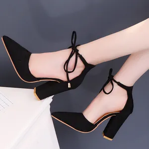 Vista detallada de los tacones negros de punta con tacón de bloque y lazada chic