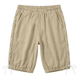 Detailed front view of men's khaki linen three-quarter pants with white side lace-up design.