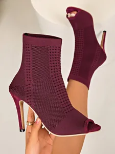 Detalle de los botines de punto color granate con puntera abierta y elegantes tacones de aguja