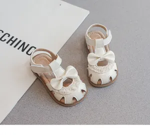 Primer plano detallado de sandalias crema para niñas con lazos y encaje elegantes