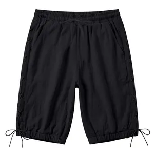 Detail view of black linen 3/4 pants featuring side lace-up design and drawstring