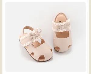 Detailopname van beige baby prinsessensandalen met delicate kant en strikjesdetails