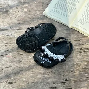 Detailed close-up of black girls' polka dot clogs with cute ruffles and bow decoration