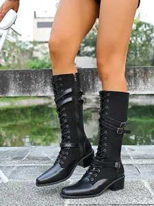 Vista detallada de botas de combate altas negras con correas con hebilla y cordones