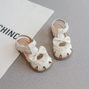 Sandalias cerradas blanco crema para niñas con lazo y detalles de encaje