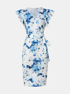 Detalle de un elegante vestido cruzado blanco con estampado floral azul y mangas de volantes.