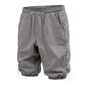 Detail view of grey linen cropped pants with side lace-up design and drawstring cuffs