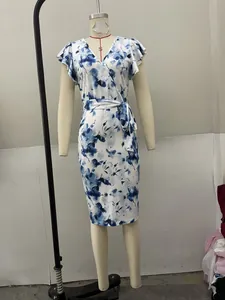 Detalle de un elegante vestido cruzado blanco con estampado floral azul en un maniquí