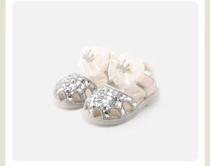Close-up view of baby princess shoes with sparkly silver sequins and bow crowns