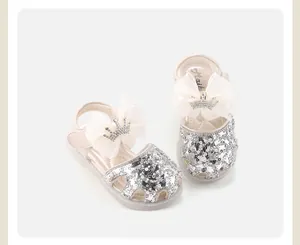 Detailed view of silver sequin baby shoes with elegant mesh bow and crown ornament.