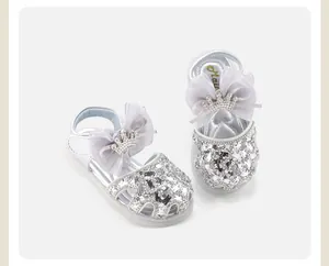 Sparkly silver sequin baby shoes with elegant tulle bow and crystal crown detail.