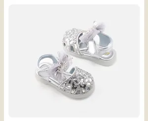 Detail view of silver sequin baby princess sandals with bow and crown accents