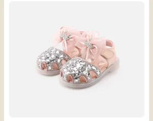 Detail of pink baby princess sandals with sequin toe and large chiffon bow decoration