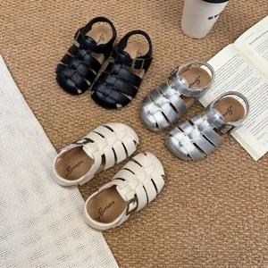 Vista detallada de sandalias romanas vintage para niños en negro, plata y crema