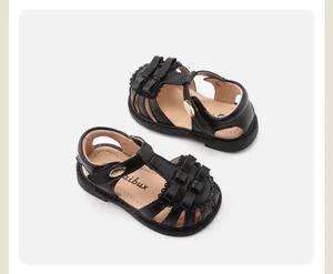Dettaglio ravvicinato dei sandali neri da bambina con elegante design a doppio fiocco