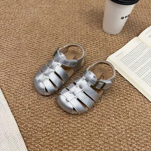 Macro detail view of silver woven children's gladiator sandals with soft non-slip sole