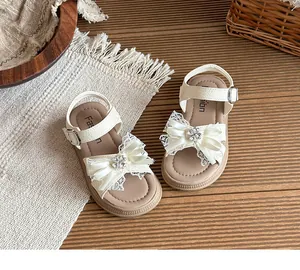 Sandales crème pour fille avec nœud en dentelle et fleur en strass