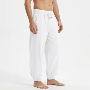 Detail of men's white loose linen joggers with drawstring waist and elastic cuffs