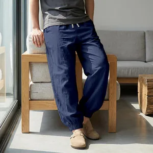 Detail view of men's navy blue linen jogger pants styled in a minimalist home setting