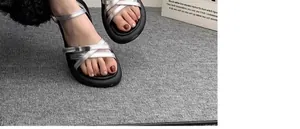 Gros plan de sandales argentées pour filles avec des semelles noires souples et confortables