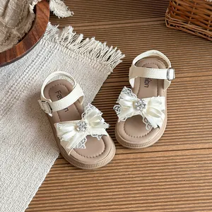 Élégantes sandales à fleurs blanc crème pour filles avec nœuds en strass sur tapis