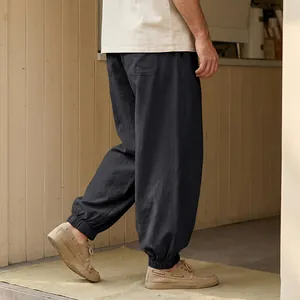 Detail view of men's loose black linen joggers with elasticated ankle cuffs for beachwear