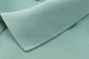 Detailed macro view of breathable ice silk pique fabric and collar on a green men's polo shirt
