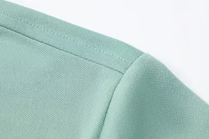Close-up of ice silk fabric and shoulder stitching on men's mint green polo shirt