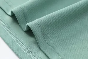 Close-up of mint green breathable ice silk polo shirt fabric texture and stitching