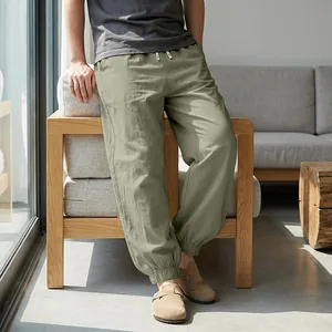 Detailed view of men's loose linen jogger pants in sage green for summer