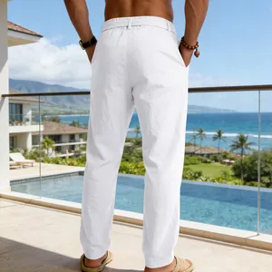 Dettaglio vista posteriore di pantaloni in lino bianco larghi su balcone resort