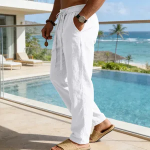 Dettaglio dei pantaloni in lino bianco da uomo con coulisse vicino a una piscina di lusso