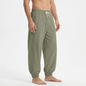 Detail of men's loose linen joggers featuring elastic ankle cuffs and drawstring