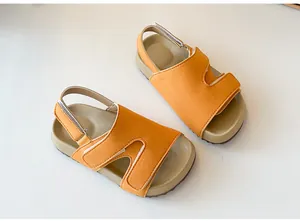 Detailansicht von orangefarbenen Kindersandalen aus Wildleder mit Klettverschluss