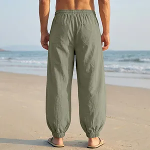 Detailed back view of men's loose olive green linen beach pants with elastic cuffs