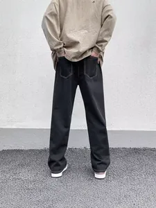 Men's classic black straight-leg jeans featuring white contrast stitching, street style back view