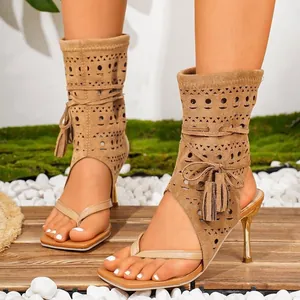 Detailansicht hellbrauner hohler Zehensandalen mit eleganten Quasten und schmalem Absatz