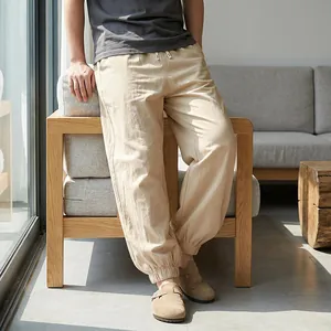 Relaxed fit men's khaki linen jogger pants shown in a cozy, natural living room setting