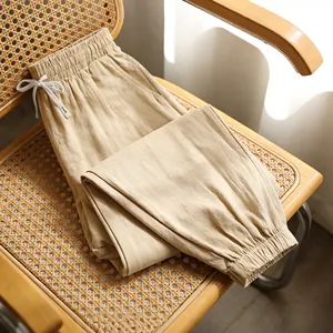 Close-up detail of beige linen men's jogger pants showing fabric texture on chair