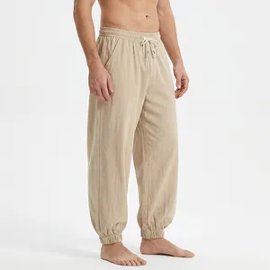Detail view of men's loose khaki linen joggers with elastic waist and drawstring.