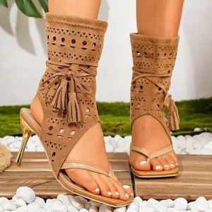 Detail der braunen Wildleder-Zehensandalen mit geometrischen Ausschnitten und Quasten