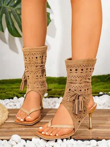 Detailansicht der lasergeschnittenen Stiletto-Sandalen mit Quasten-Dekoration