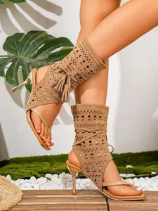 Detailaufnahme brauner Stöckel-Sandalen mit Quasten und elegantem Ausschnitt-Design