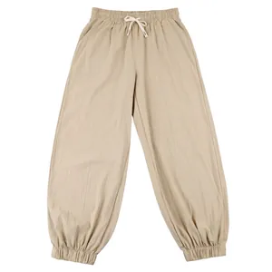 Detailed view of men's loose linen trousers with drawstring waist and elastic cuffs